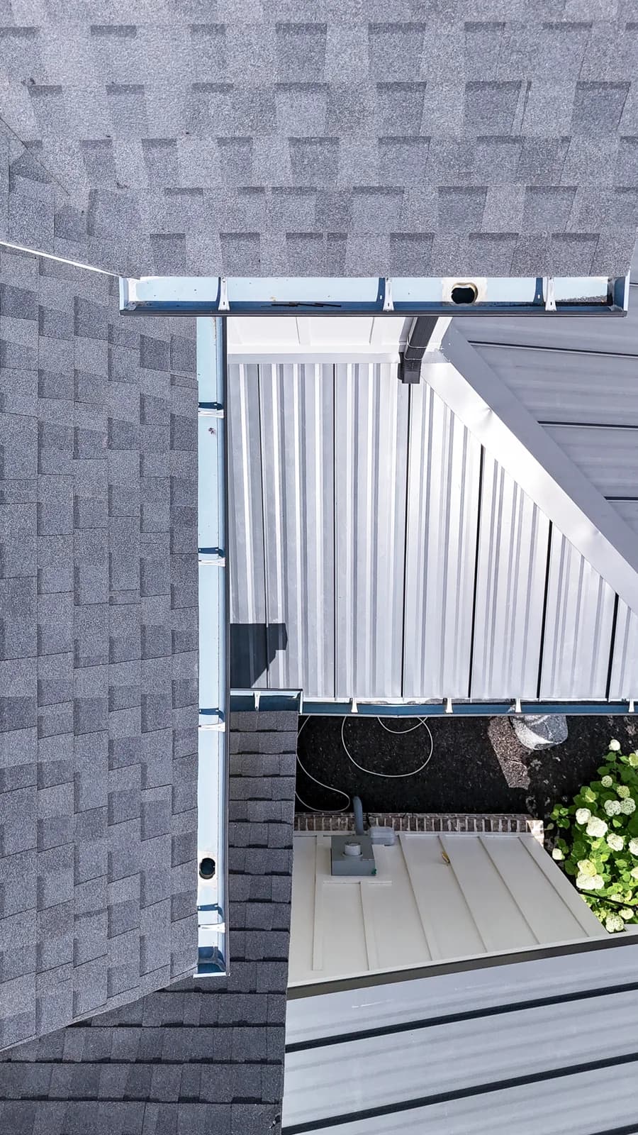 High overhead view of perfectly clean gutter channel with clear downspout opening from drone